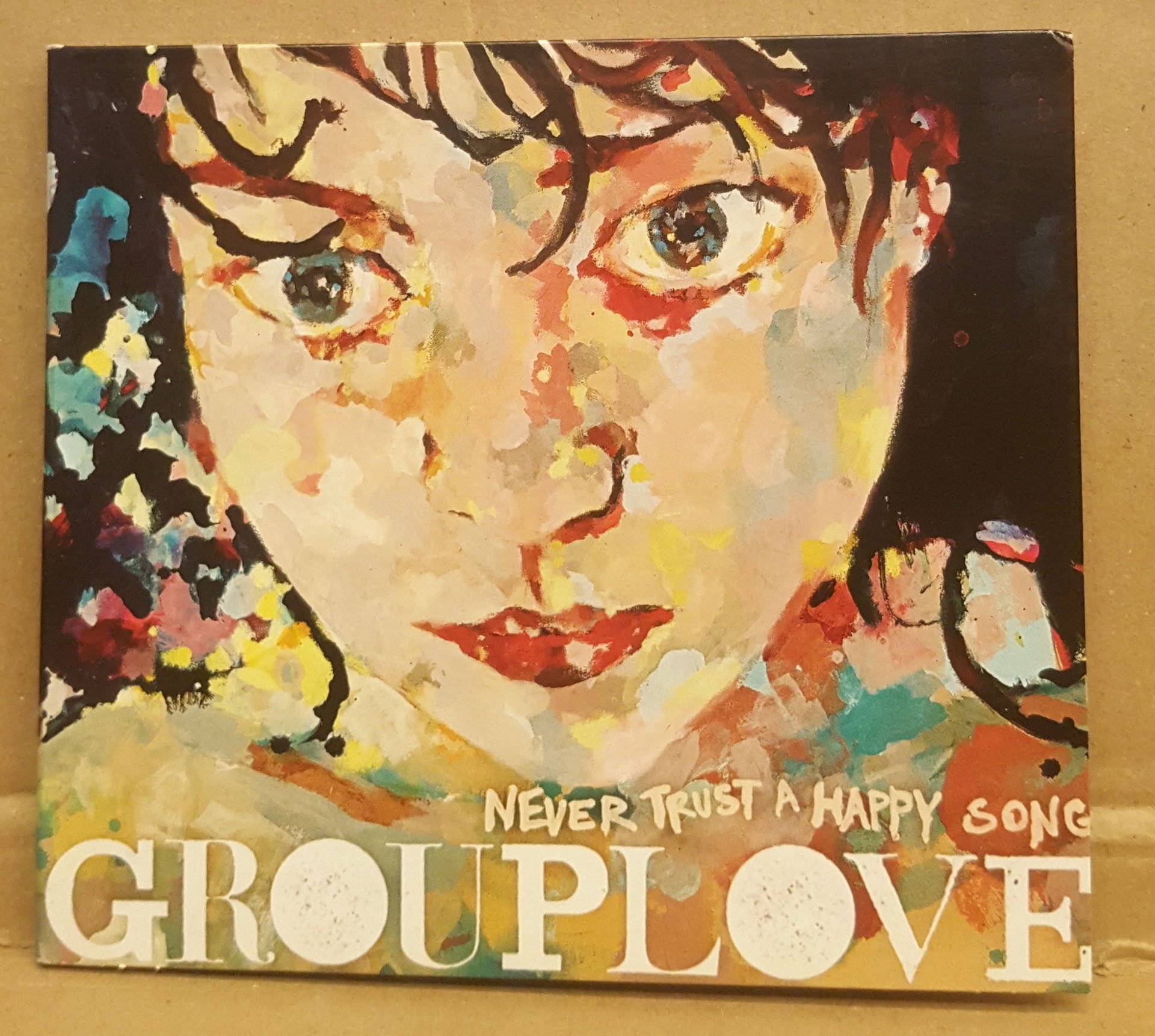 GROUPLOVE - NEVER TRUST A HAPPY SONG (2011) - CD INDIE ROCK DIGIPACK 2.EL